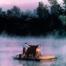 two people on a raft floating on a river
