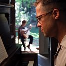a man playing piano and a boy playing guitar