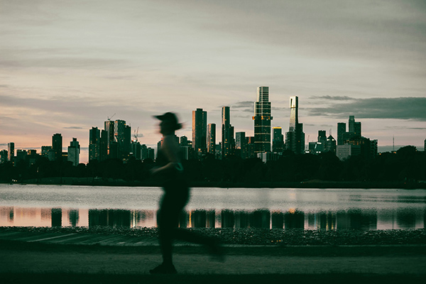 a woman running in front of a city skyline