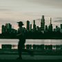 a woman running in front of a city skyline