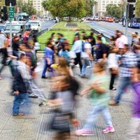 Blurred photograph of people walking on a crowded street