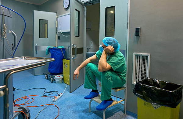 a tired doctor sitting in an operation room