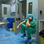 a tired doctor sitting in an operation room