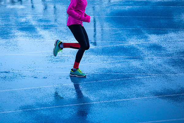 a woman running on wet pavement