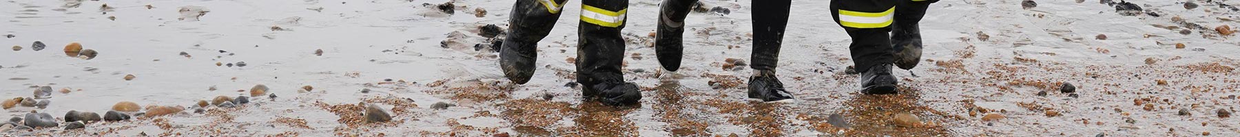Coastguard officers help a woman ashore in Dover, Kent