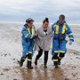 Coastguard officers help a woman ashore in Dover, Kent