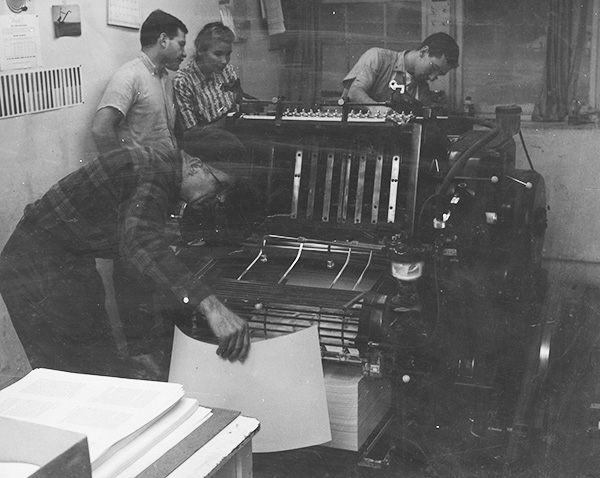 people working in a Plough print shop