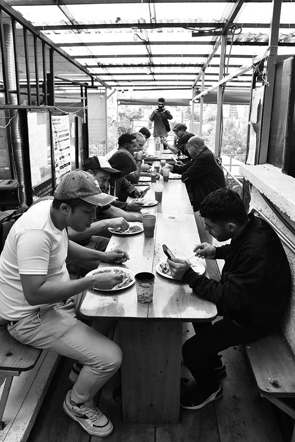 men eating at a long table
