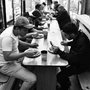 men eating at a long table