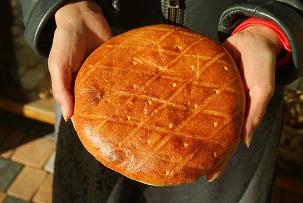 a woman holding an Armenian pastry