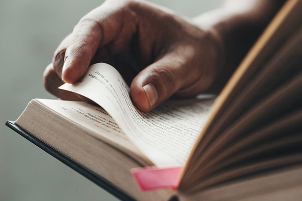 Young man opening and reading a book