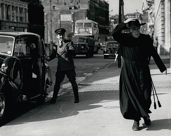a priest walking down a street