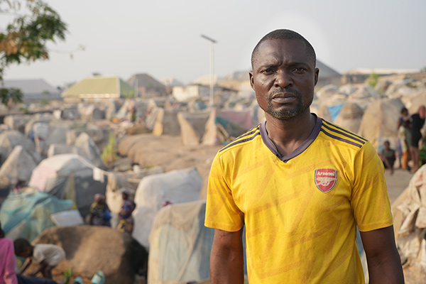 a man standing in a refugee camp