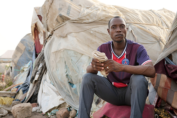 a man sitting in a refugee camp