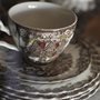 a teacup on a stack of china plates