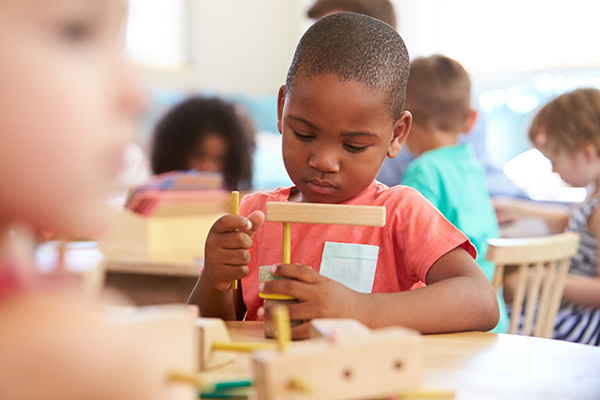 a boy playing with blocks in a Montessori classroom
