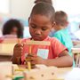 a boy playing with blocks in a Montessori classroom