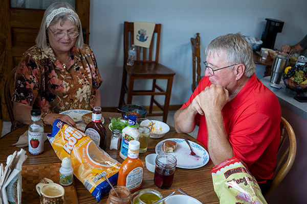 an elderly couple eating a meal in their kitchen