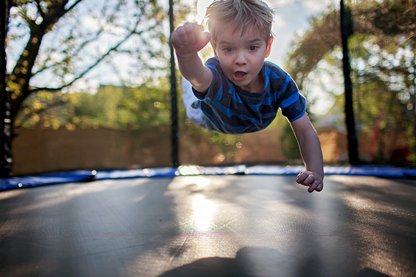 a boy bouncing on a trampoline