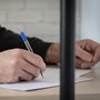 a man writing a letter behind bars