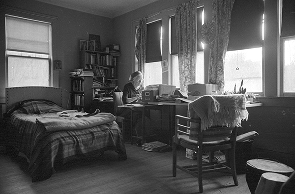 Dorothy Day writing at a desk