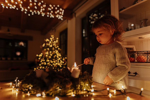 a little girl lighting an Advent candle