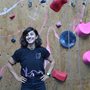 a woman standing next to a climbing wall