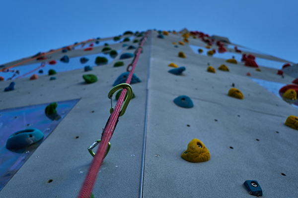 a climbing wall with a rope and caribiner