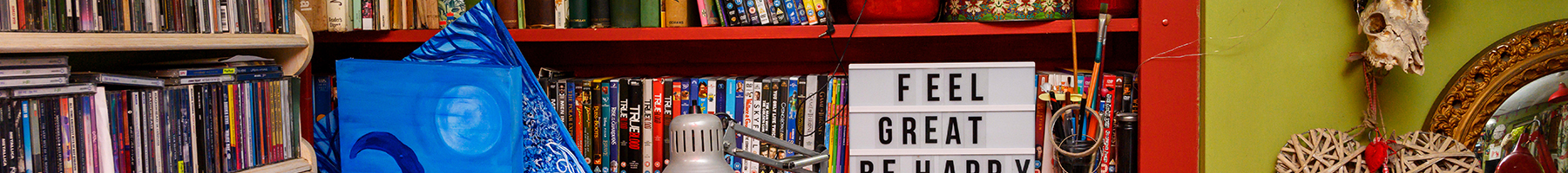 cluttered shelves filled with books, antiques and art