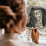 a women looking at a reflection of Hildegard von Bingen in a mirror