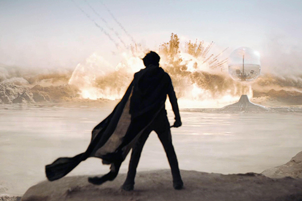 silhouette of a man standing in a desert landscape