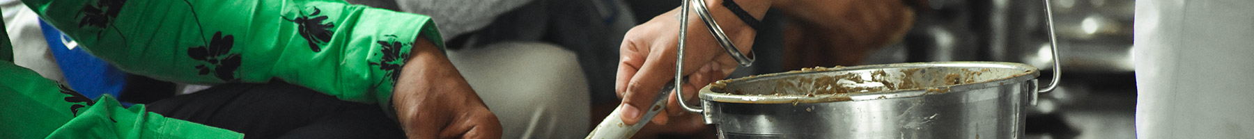 a man serving food in a community kitchen in India