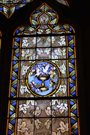 Stained glass window in blue and tan with doves in the center.