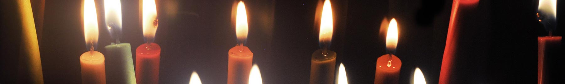 Colored candles shining on a dark background