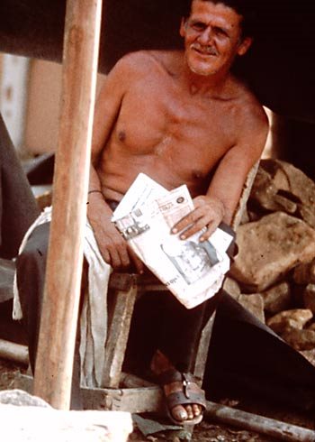 Smiling shirtless man in a Columbian shack