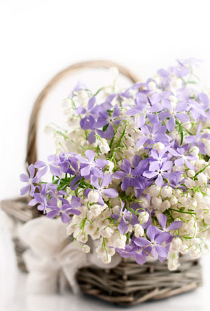 a basket with thrift and lily-of-the-valley