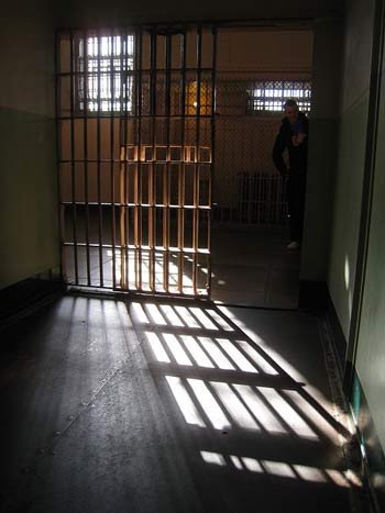 a cell on the D block at Alcatraz with light shining through the bars of the door