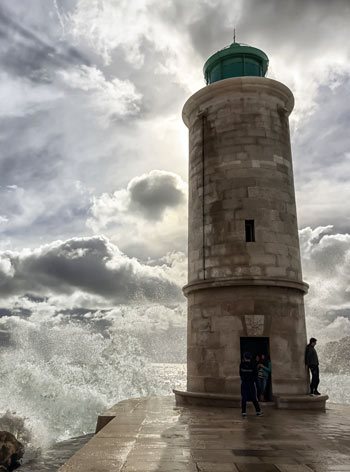 Marseille Lighthouse with dark clouds and waves crashing