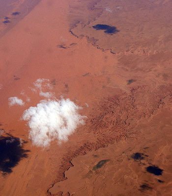 Flying above clouds looking down on the Sahara desert.