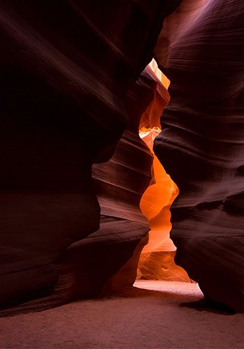 orange light shining between mauve rocks in Antelope Canyon in Arizona