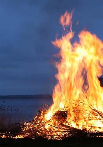 A bonfire at night by a lake