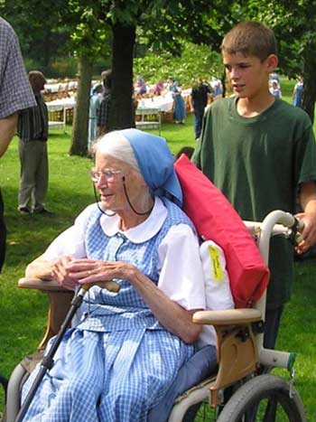 A boy pushes his grandmother in a wheelchair