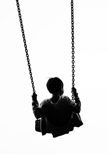 silhouette of a boy on a swing