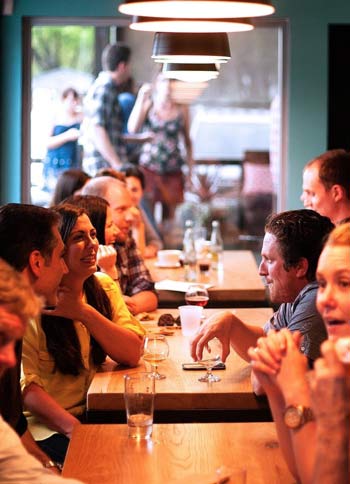 people conversing with each other across a cafe table