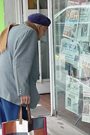 Elderly man reading Spanish-language newspapers on the street in Argentina.