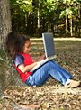 girl under a tree with a laptop