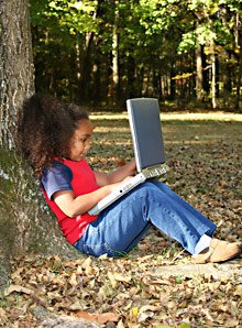 girl under a tree with a laptop