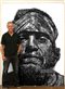 Neil Shigley standing by one of his large portraits of homeless people. 
