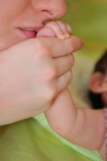 mother kissing babys hand