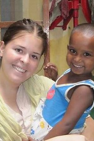 Kayla Mueller in India, holding a young child.